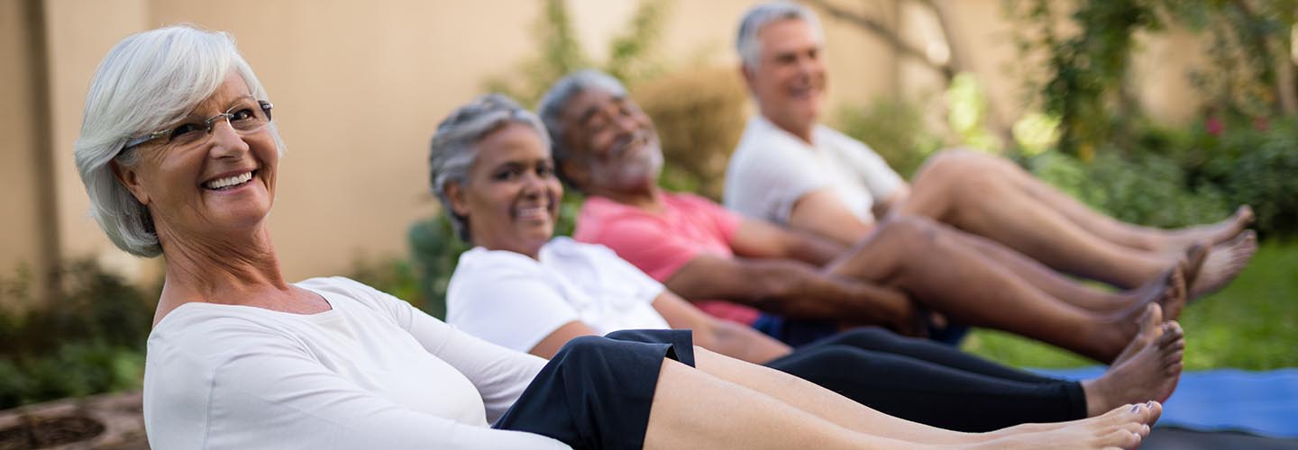 Smiling senior people exercising with feet up