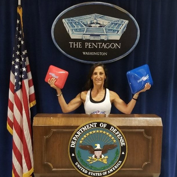 andrea hammer holding red and blue maxpac standing at pentagon press podium